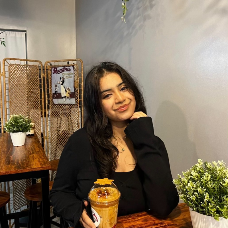 Khushi Chadha smiling at a café table